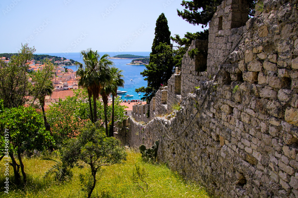 Steep stone wall of the Spanjola Fortress above the village of Hvar with a view over the old port of Hvar on Croatia