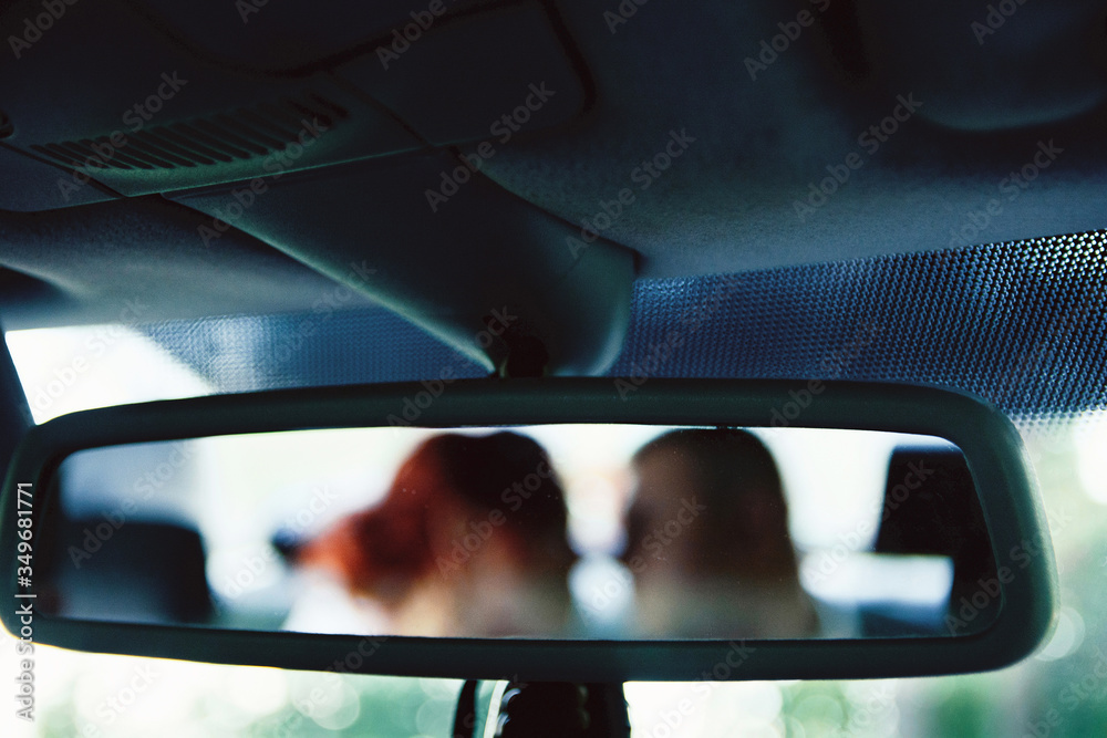 bride and groom in the rearview mirror reflection redhead blurred background

