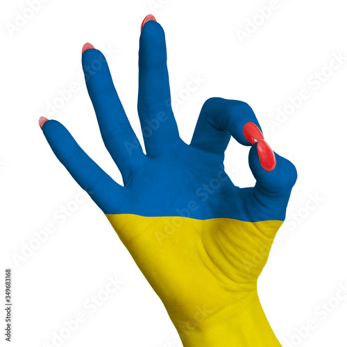 The national flag of Ukraine is painted on a female hand showing the OK sign.