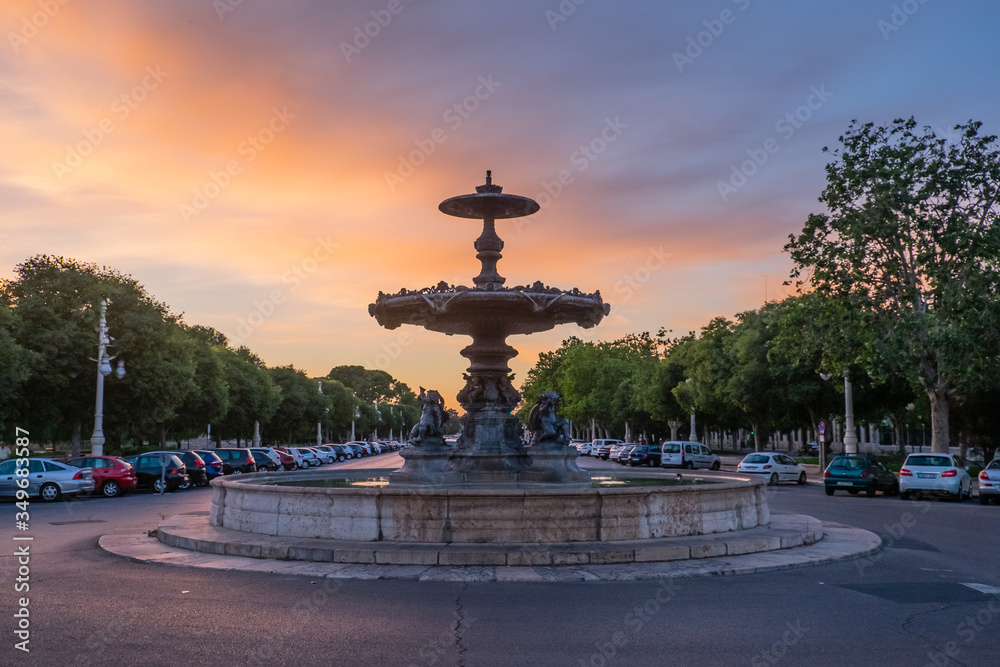 Fountain illuminated with the colors of the sunset after the rain in Valencia Fountain illuminated with the colors of the sunset after the rain in Valencia