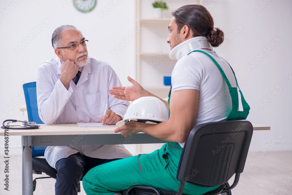 Obraz premium Young male contractor visiting old doctor
