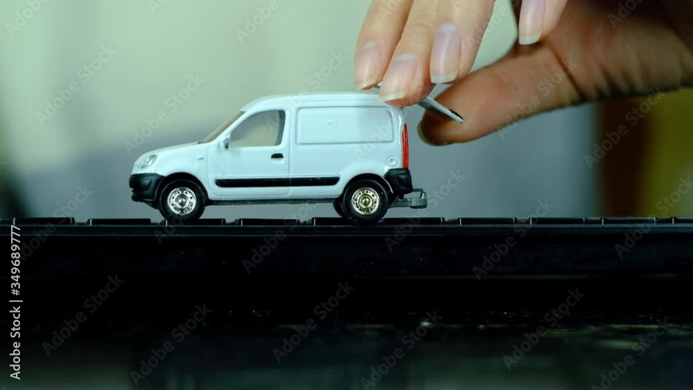 The girl is played by a small car on a black computer keyboard The girl is played by a small car on a black computer keyboard