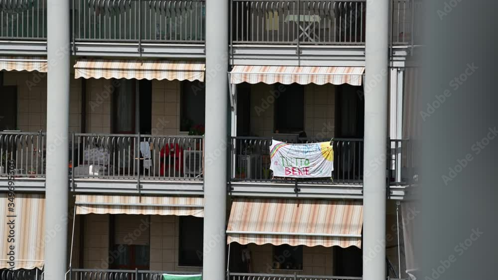 Turin, Piedmont, Italy. May 2020. Coronavirus pandemic. On the facades of the houses hang the sheets with the drawing of the rainbow and message everything will be fine. In Italian 