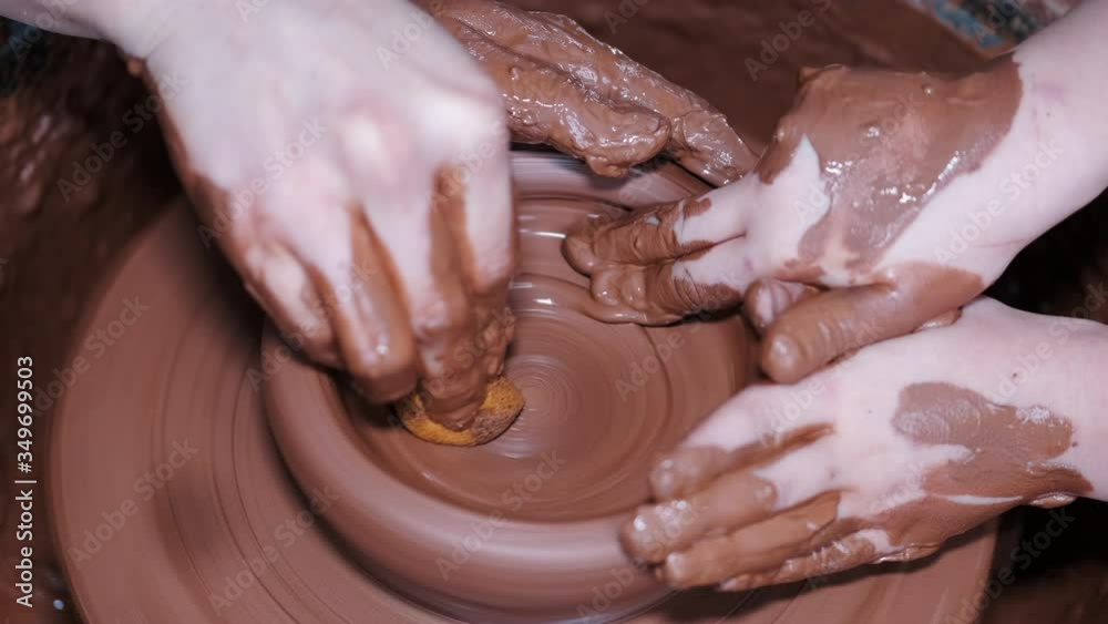 Artist and student work in creative studio. Woman and kid use pottery wheel. Hands of potters are anointed with clay. Artist and student work in creative studio. Woman and kid use pottery wheel. Hands of potters are anointed with clay.
