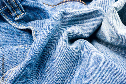 clothing items blue stonewashed faded jeans cotton fabric texture with seams, clasps, buttons and rivets, macro, close-up