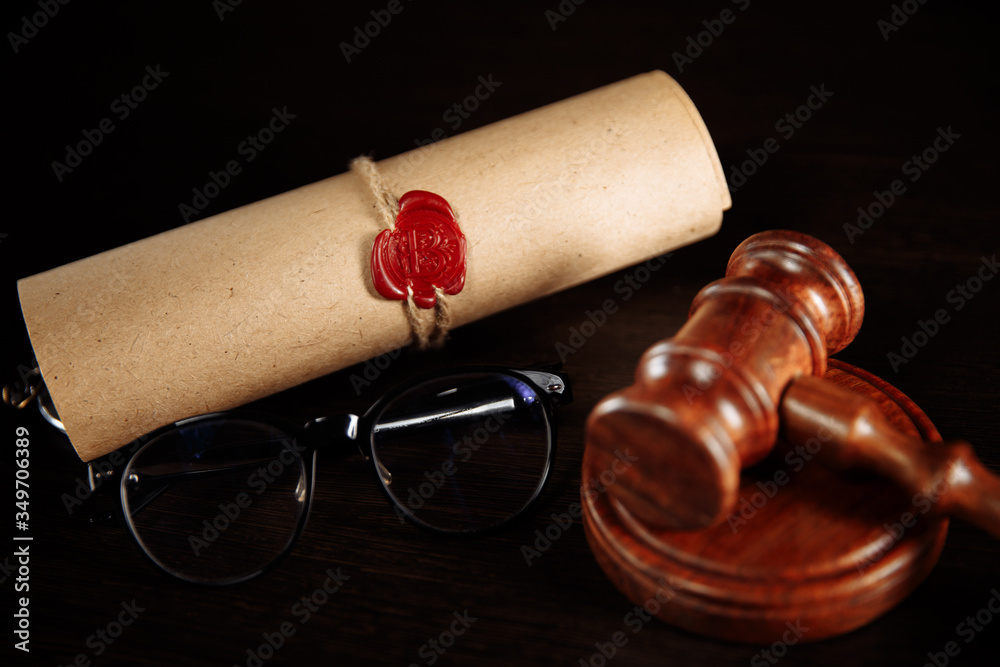 Wooden gavel and glasses near testament and last will. Notary public tools close-up.