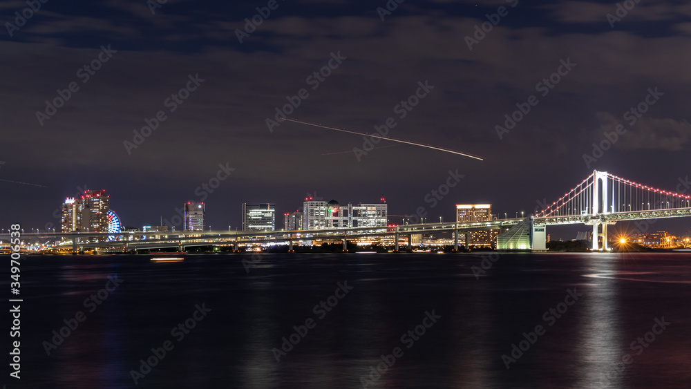 芝浦ふ頭から見たレインボーブリッジとお台場の夜景と飛行機、船の光跡