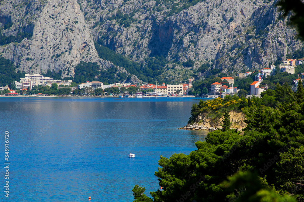 Omis village by the Adriatic Sea in Croatia, overlooked by rugged mountains, seen from the distance