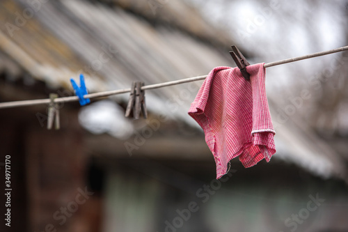 Foto A red cleaning cloth dries on a rope in the courtyard of a village house