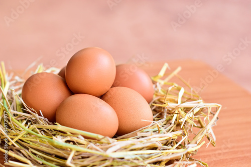 Eggs placed in a nest made from rice straw on wood table