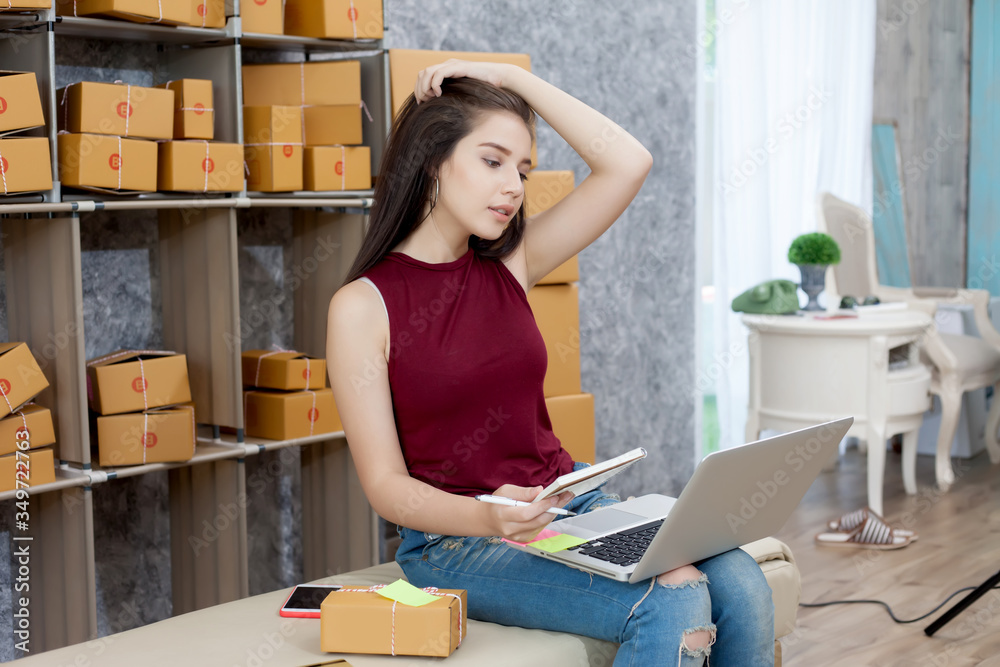 Startup small business owner working at house. Young asian woman happy with the sale of goods online. Student who work with careers supplemented by online sales via social media.