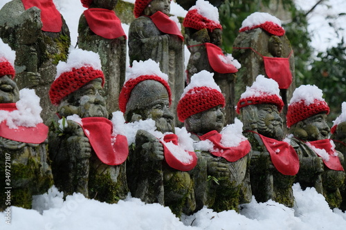 高尾山の仏様。日本の冬の里山歩き、高尾山、東京都。Snow field with old Stone monument. Trekking at Mt. Takao, Tokyo Japan. 