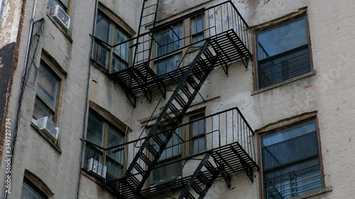 City fire escapes on white brick building.