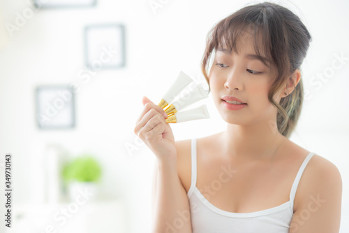 Beautiful portrait young asian woman holding and presenting cream or lotion product  beauty asia girl show cosmetic makeup and moisturizing for skin care  healthy care and wellness concept.