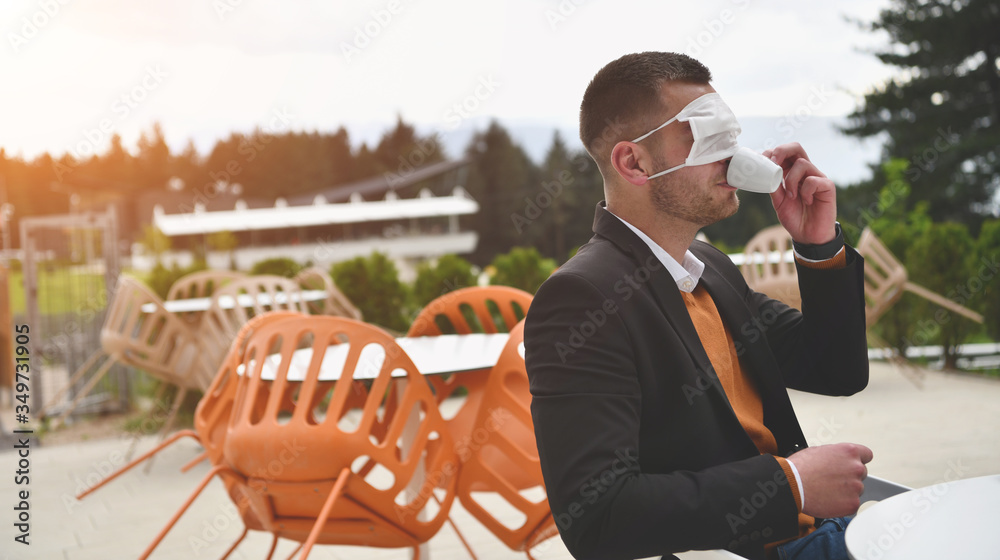 funny man in restaurant drinking coffee wearing face mask - obrazy, fototapety, plakaty 