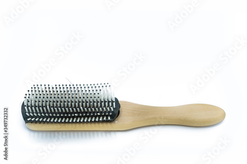 Wooden handle Comb with hairs loss on white background.