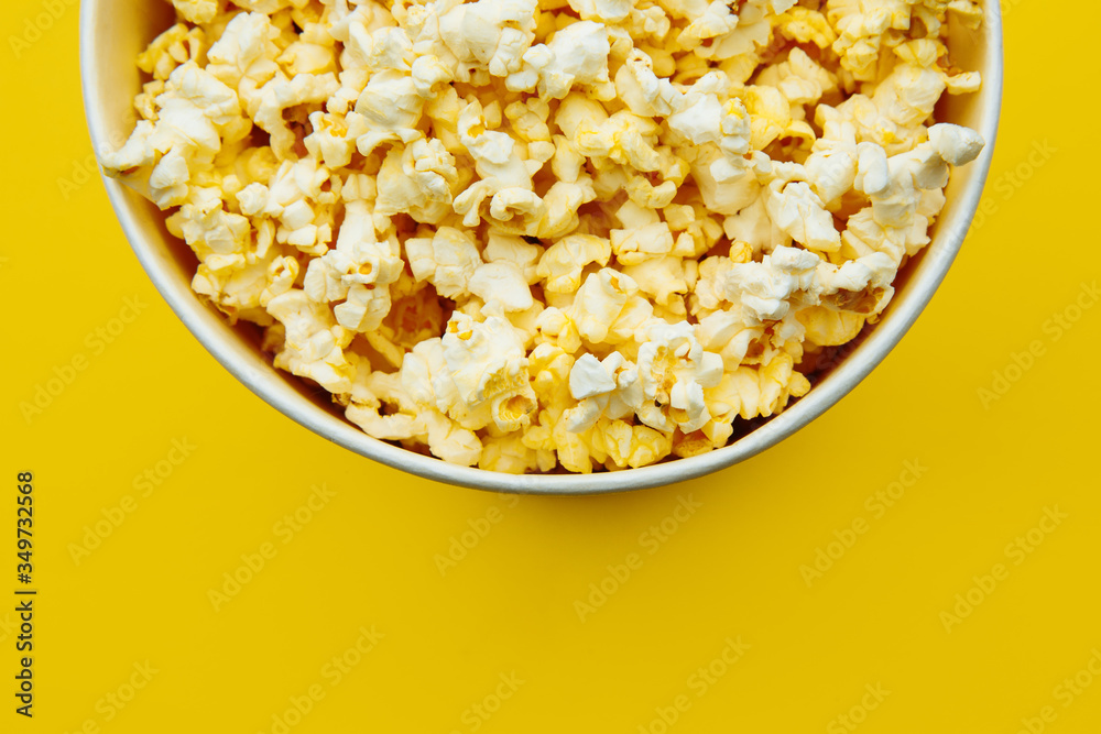 Popcorn in a bowl on yellow background, top view. Entetainement concept. Popcorn in a bowl on yellow background, top view. Entetainement concept.
