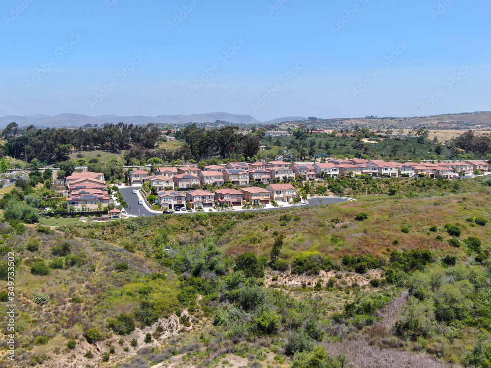 Aerial view of upper middle class neighborhood with residential houses in green valley, South California, USA.