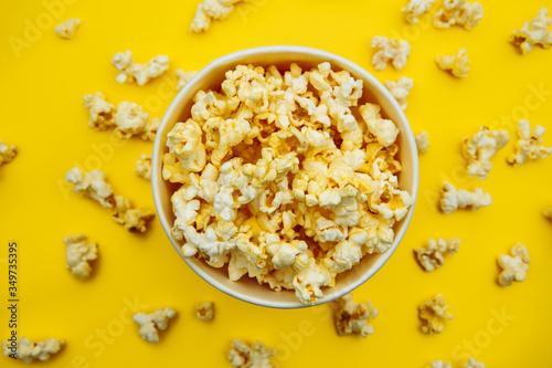 Bowl with popcorn on yellow background. Top view. Entetainement concept.
