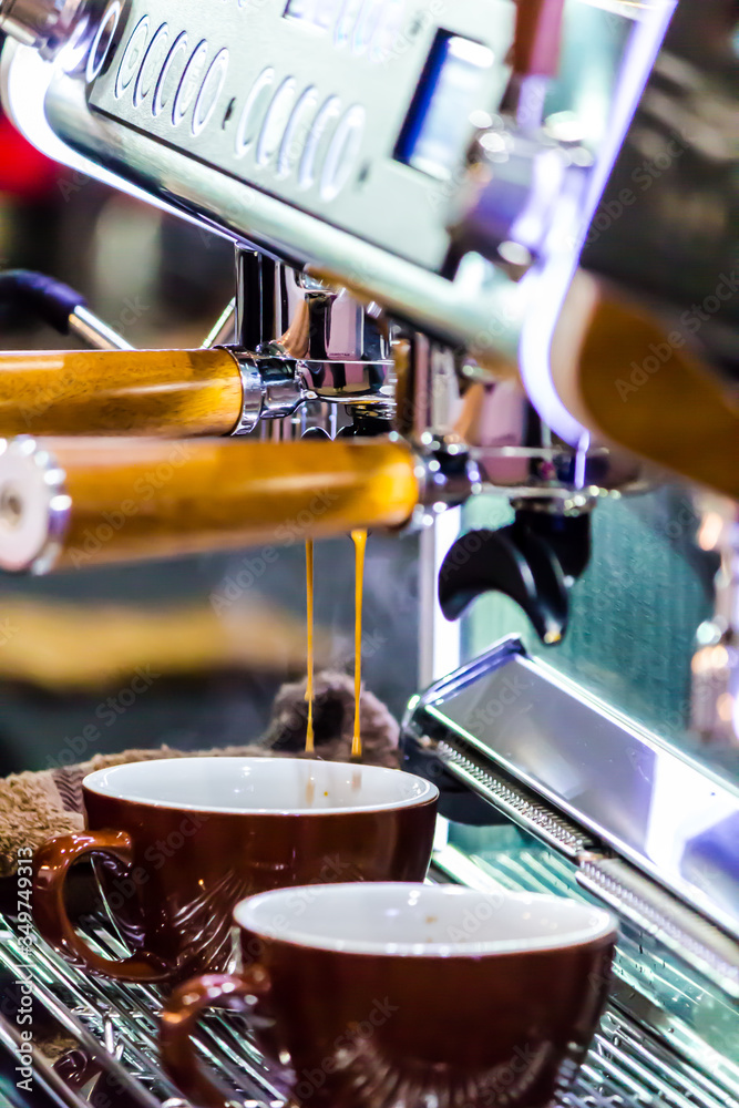 Espresso Machine pouring fresh coffee into cups at Local Coffee Shop..