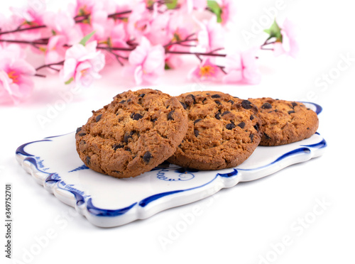 cookie with chocolate chips close-up on a sprig of cherry blossoms  white background
