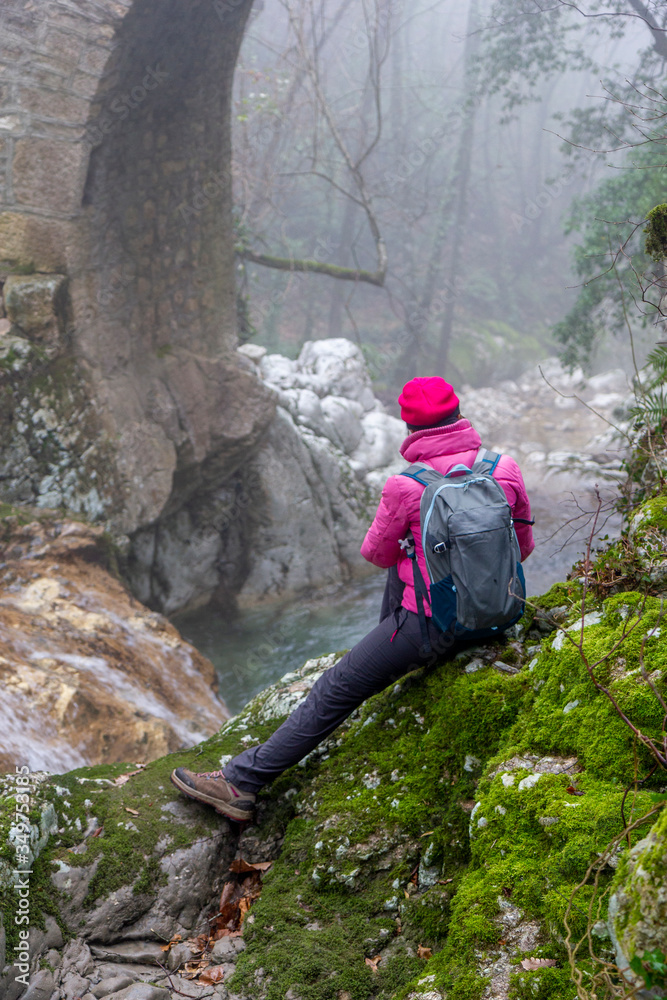 woman hiker photographing waterfall in sassinoro and fog