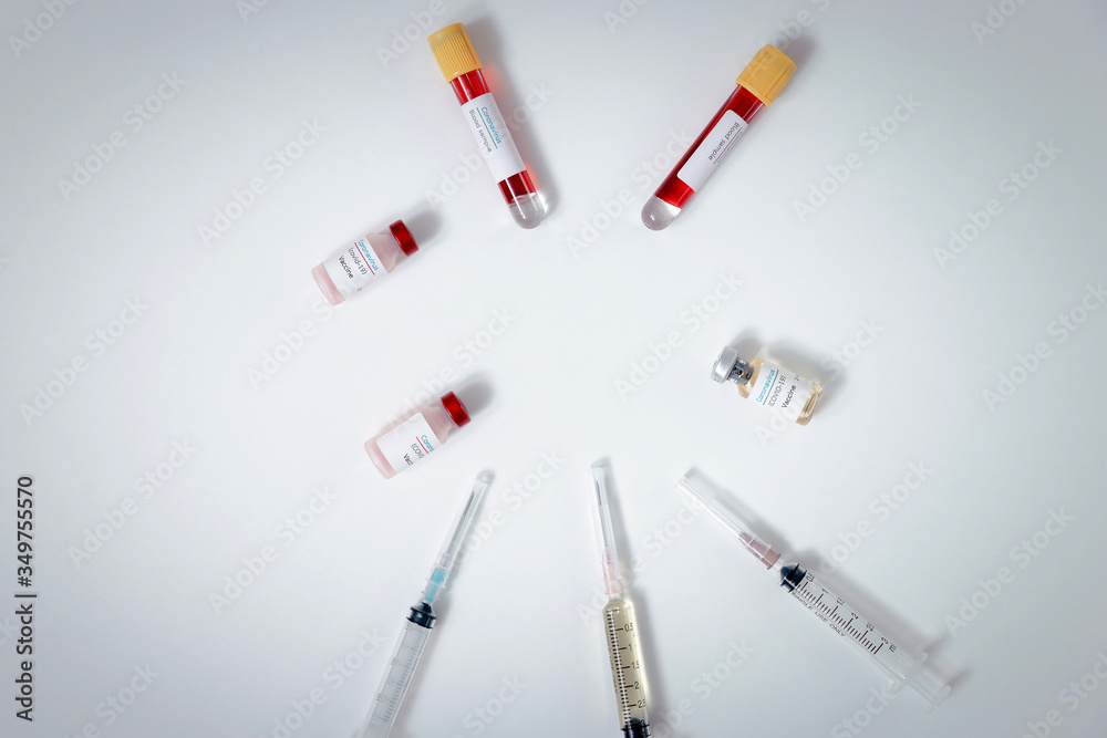 Top view of vaccine, blood samples in tubes and syringes on work table in a medical examination lab. Top view of vaccine, blood samples in tubes and syringes on work table in a medical examination lab.