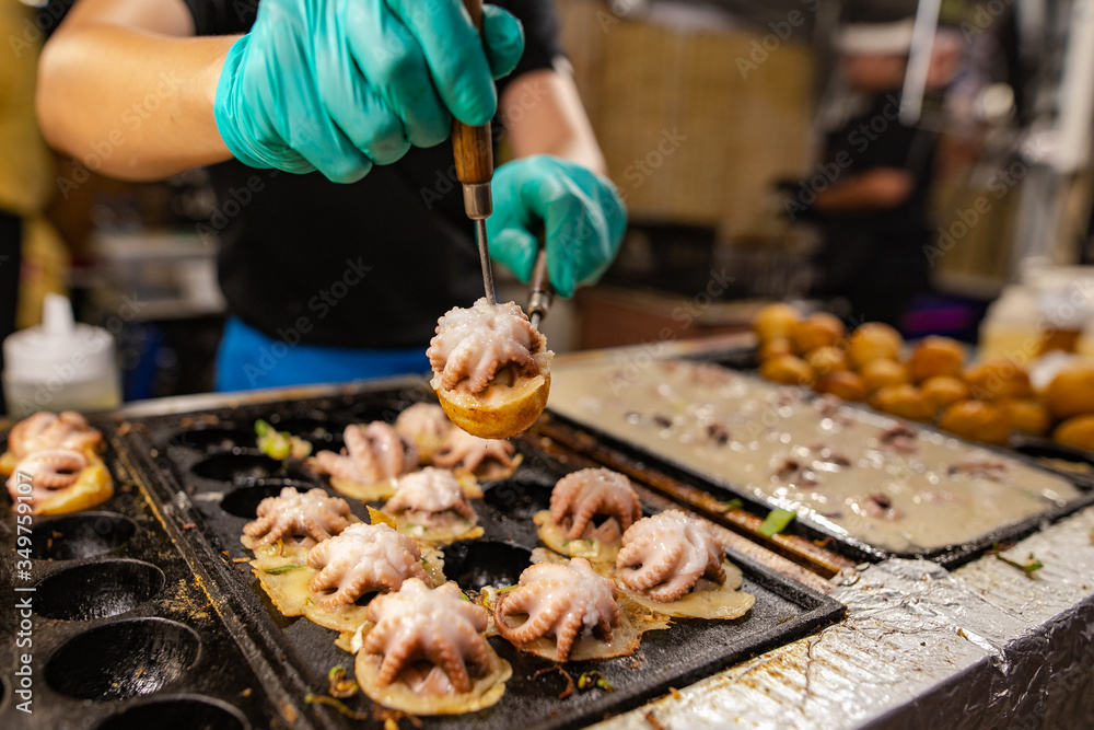 Blurry image Man doing octopus takoyaki Is a snack of Japanese people When chewing the squid, it feels crunchy, combined with the softness of the flour used to make it delicious.