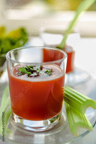 Wallpaper Mural Two glasses of tomato juice with parsley and celery decorations, stand near the window, morning sunlight shines, shallow depth of field, selective focus. Natural drinks concept. Torontodigital.ca
