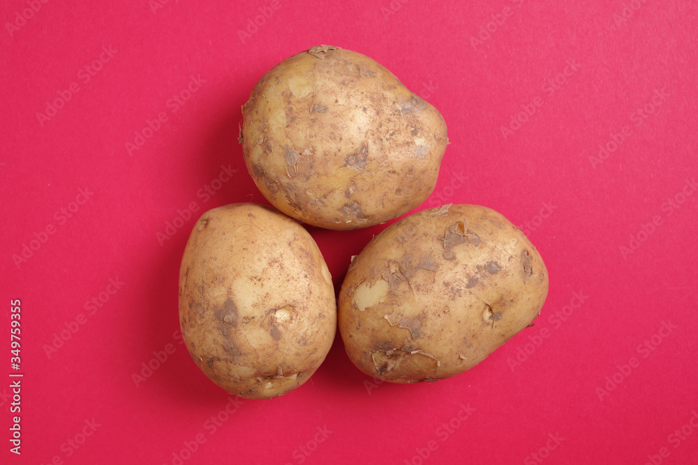 Raw potatoes on red