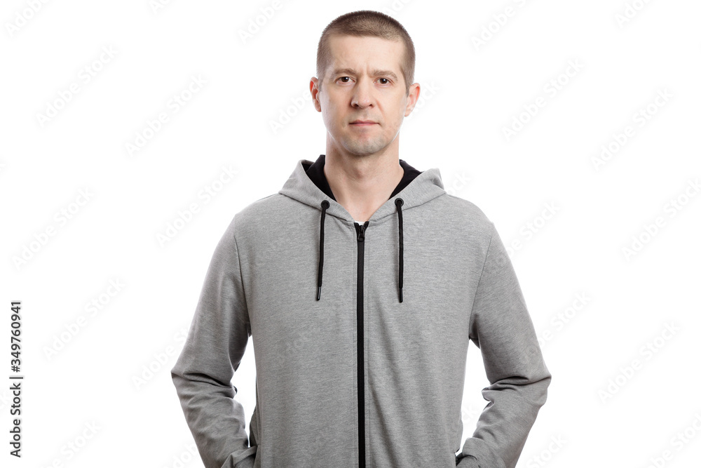 A sports strong athlete is a man, wearing a hooded jacket, his hands in his pockets. A look into the camera. Isolated A sports strong athlete is a man, wearing a hooded jacket, his hands in his pockets. A look into the camera. Isolated