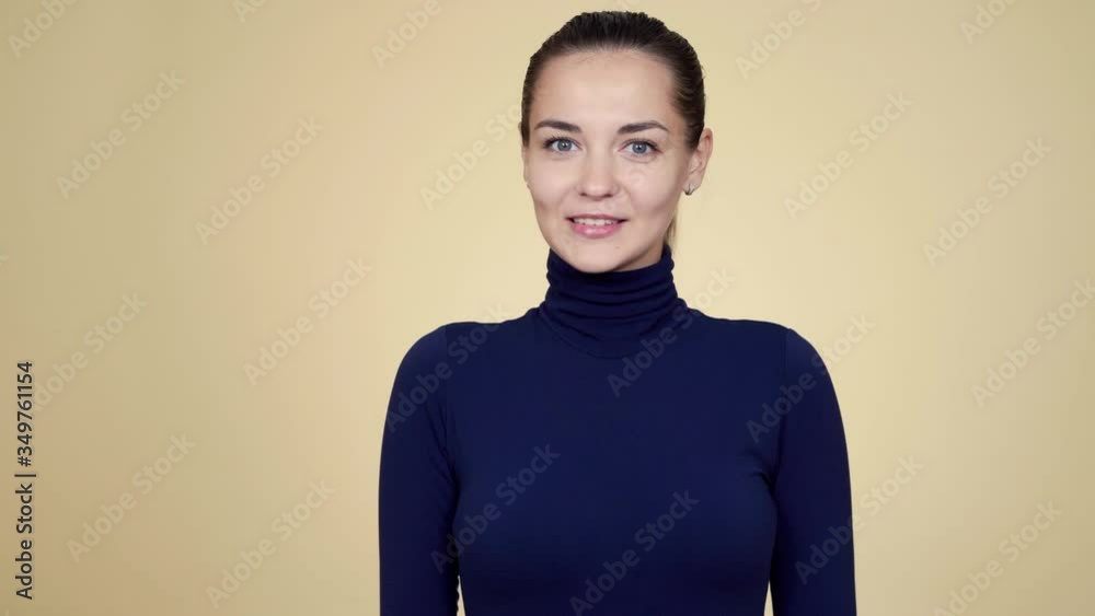 Portrait of pretty woman looking at camera, smiling isolated on beige background Portrait of pretty woman looking at camera, smiling isolated on beige background