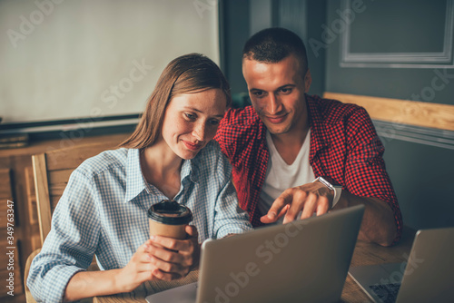 Couple of freelancers with laptop searching information on internet