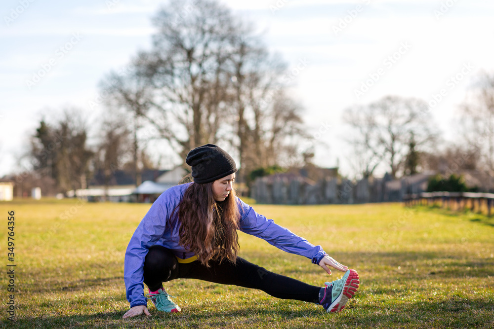 A young Caucasian woman in sportswear is engaged in warm-up and fitness in the Park. Concept of sport, health and active life A young Caucasian woman in sportswear is engaged in warm-up and fitness in the Park. Concept of sport, health and active life