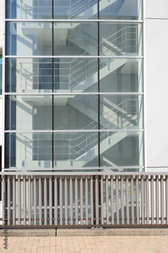 Side view of metal stairs inside the building on exit way connect to underground with sunlight shine through window glass Side view of metal stairs inside the building on exit way connect to underground with sunlight shine through window glass