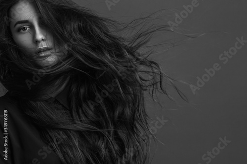 Portrait of a young beautiful girl with luxury hair flying (black and white photo)