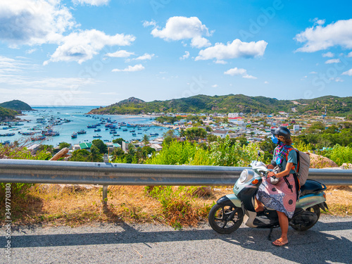 One person riding motorbike on winding road looking at view of gorgeous coast in the Phu Yen province  Nha Trang Quy Nhon  adventure traveling in Vietnam. Unique tropical bay and golden beach.