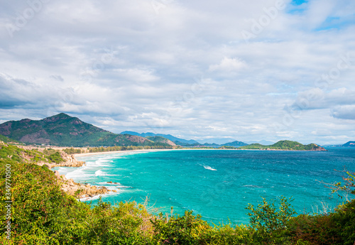 Secluded tropical coast line turquoise transparent water palm trees, undeveloped bay Quy Nhon Nha Trang, Vietnam central coast travel destination, no people clear blue sky, expansive view