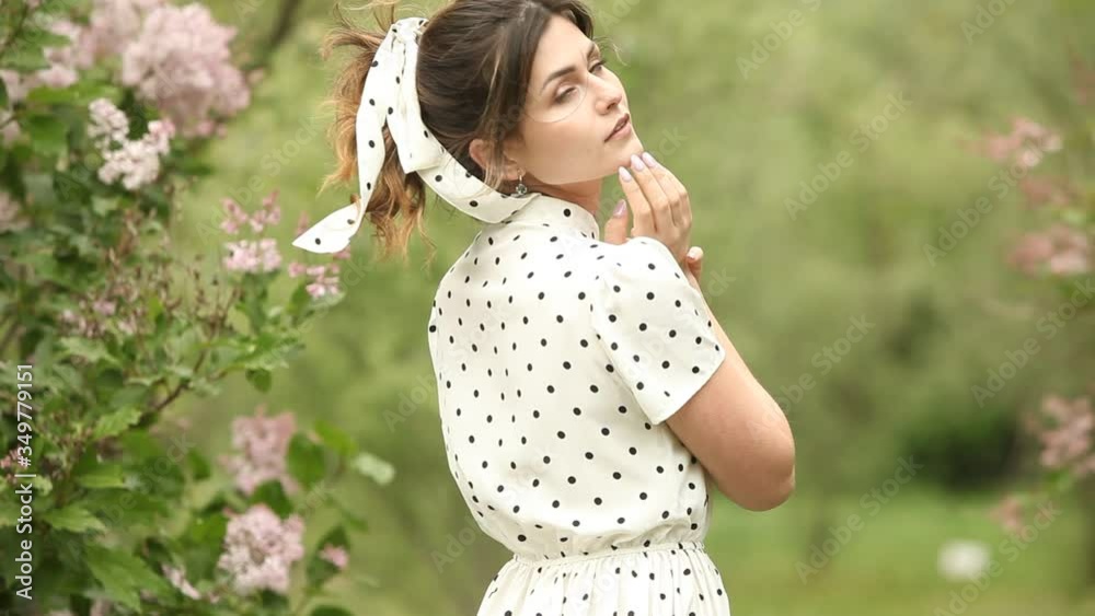 Woman's portrait with a hair moving in the wind. Close-up portrait of young beautiful Russian brunette girl at summer green park. European white woman in dress. Woman's portrait with a hair moving in the wind. Close-up portrait of young beautiful Russian brunette girl at summer green park. European white woman in dress.
