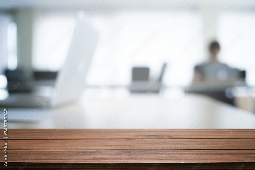 Empty wooden desk space over blurred office or meeting room background. Product display. Empty wooden desk space over blurred office or meeting room background. Product display.