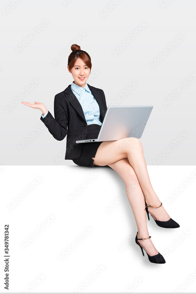 young Business woman with laptop sitting on blank billboard placard sign young Business woman with laptop sitting on blank billboard placard sign