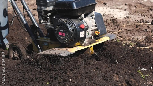 Wallpaper Mural Agricultural work on plowing the field for sowing seeds. a man plows the land with the help of motor cultivator. Torontodigital.ca