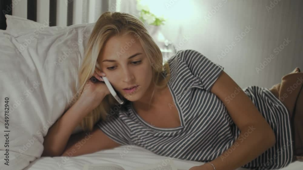 Young woman talking on mobile phone in bed Young woman talking on mobile phone in bed