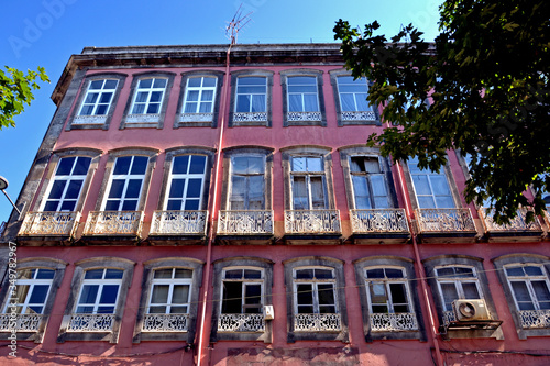 Porto, Portugal - August 18, 2015: Beautiful pink facade of a building looking like a school in summer.