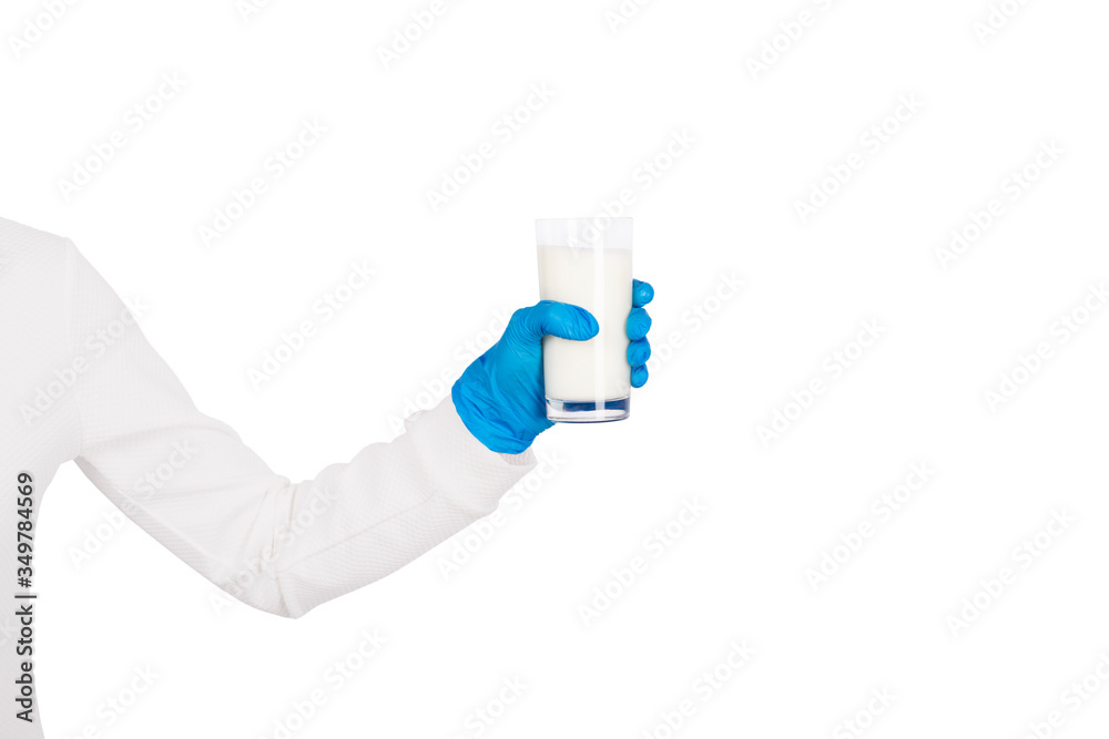 Female hand in disposable glove holds glass of milk or yogurt. Female hand in disposable glove holds glass of milk or yogurt.