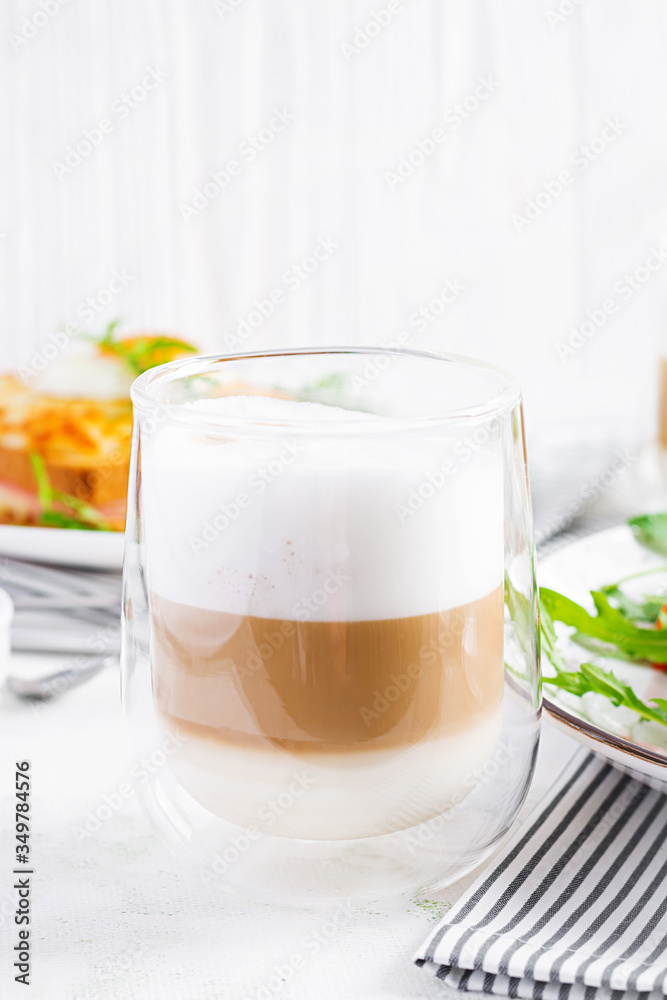 Coffee cafe latte macchiato in a glass on  light background. Italian cuisine