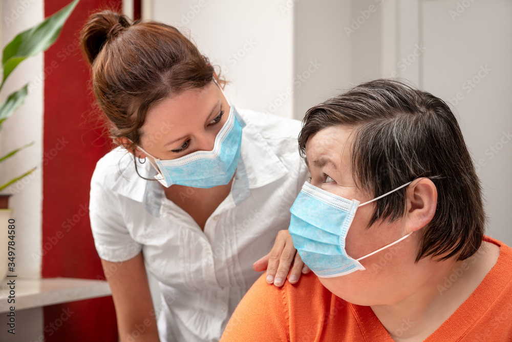 Mentally disabled woman and nurse or caretaker wearing a surgical mask, covid-19 Mentally disabled woman and nurse or caretaker wearing a surgical mask, covid-19