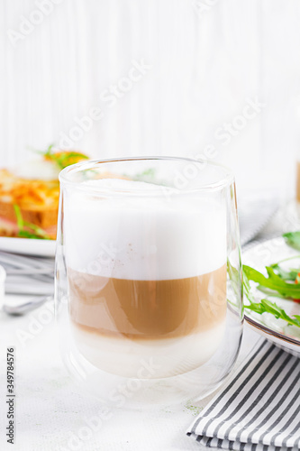 Coffee cafe latte macchiato in a glass on light background. Italian cuisine