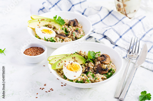 Breakfast oatmeal porridge with green herbs of mushrooms, boiled egg, avocado and flax seeds. Healthy balanced food.