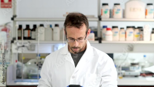 Research scientist checking the results on his cell phone and looking at the camera and gesturing thumb up